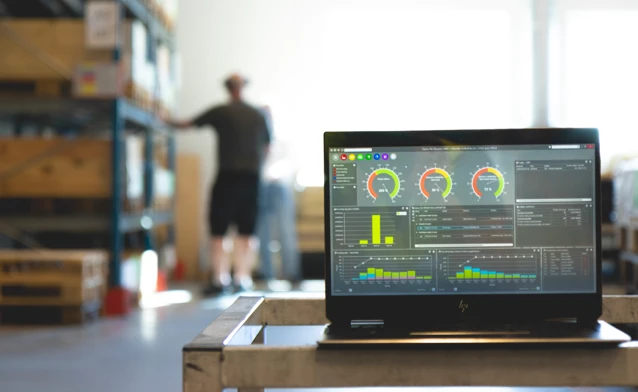 Monitor ERP instrumentpanel visas på en laptop i en fabriksmiljö.