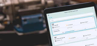 A person holding a tablet computer in a factory.