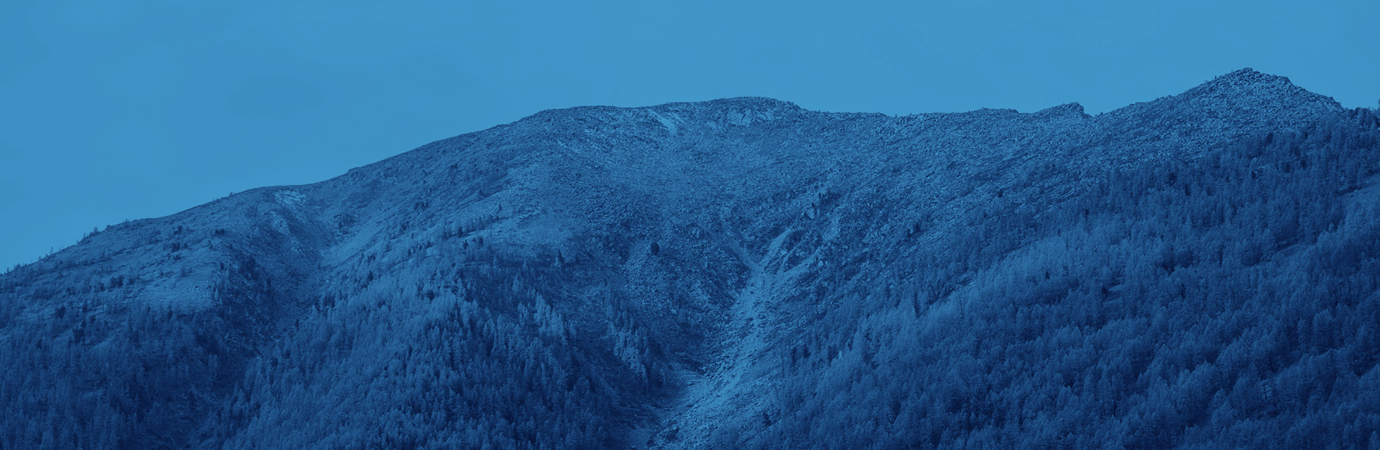 A mountain covered in snow under a blue sky.