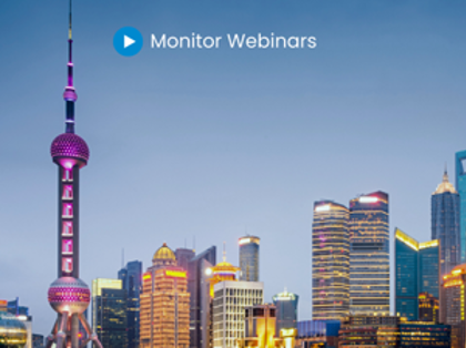 A picture of a city at night with the words monitor webinars.