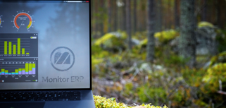 Illustration of Monitor ERP dashboards on a screen placed in nature, symbolizing sustainability.