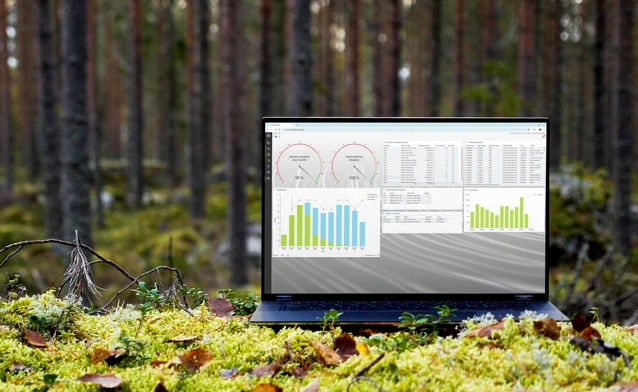A laptop computer sitting on top of a moss covered field.