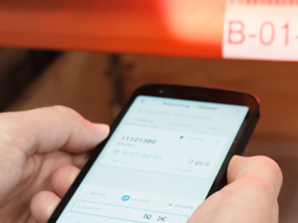 Warehouse employee scanning a pallet label with Monitor Mobile for mobile picking and inventory management