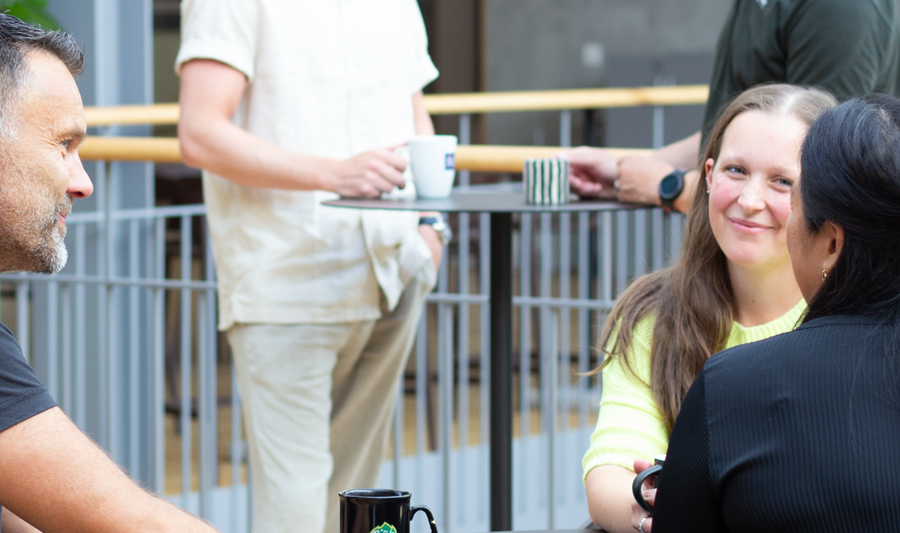 Employees at Monitor sitting and drinking coffee together. 