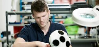 En man som håller en vit boll med hål i.