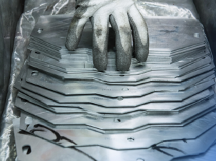 A hand that is sitting on top of a piece of metal.