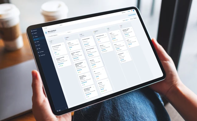 A person holding a tablet displaying the Monitor CRM dashboard with incoming cases.