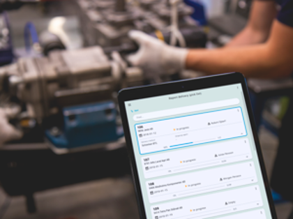 A person holding a tablet computer in a factory.
