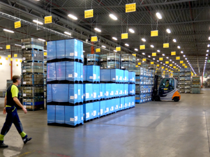 A man walking through a warehouse with pallets and warehouse logistics connected through EDI integration in Monitor ERP