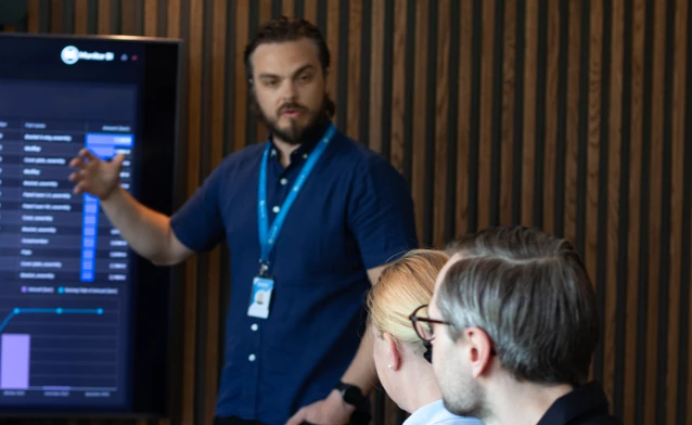 A man at Monitor ERP giving a presentation to a group of people about Monitor BI (business intelligence)