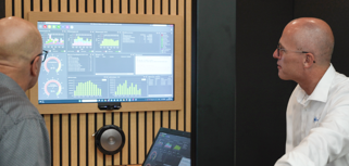 Two people looking at a computer with Monitor ERP dashboard.