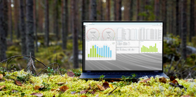 A laptop computer with Monitor ERP dashboard (sustainability functions) sitting on top of a moss covered field.