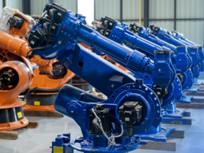 A row of orange and blue machines in a warehouse.