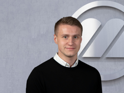 A man standing in front of a logo.