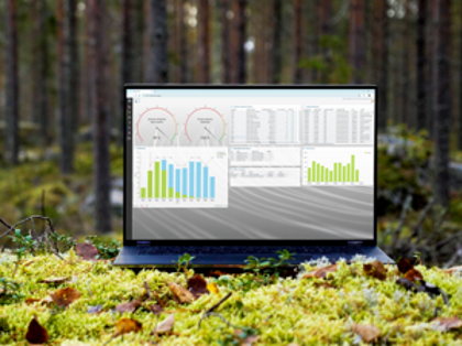 A laptop computer sitting on top of a moss covered field.